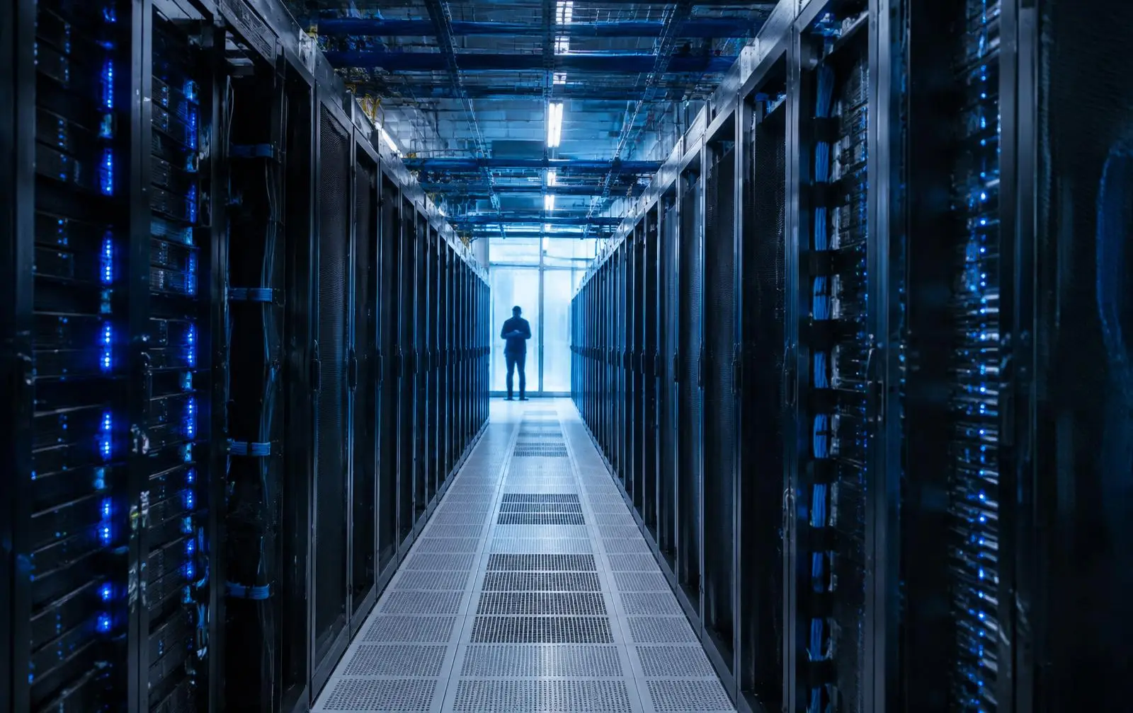 Aisle of GPU server racks in a data centre with blue indicator lights