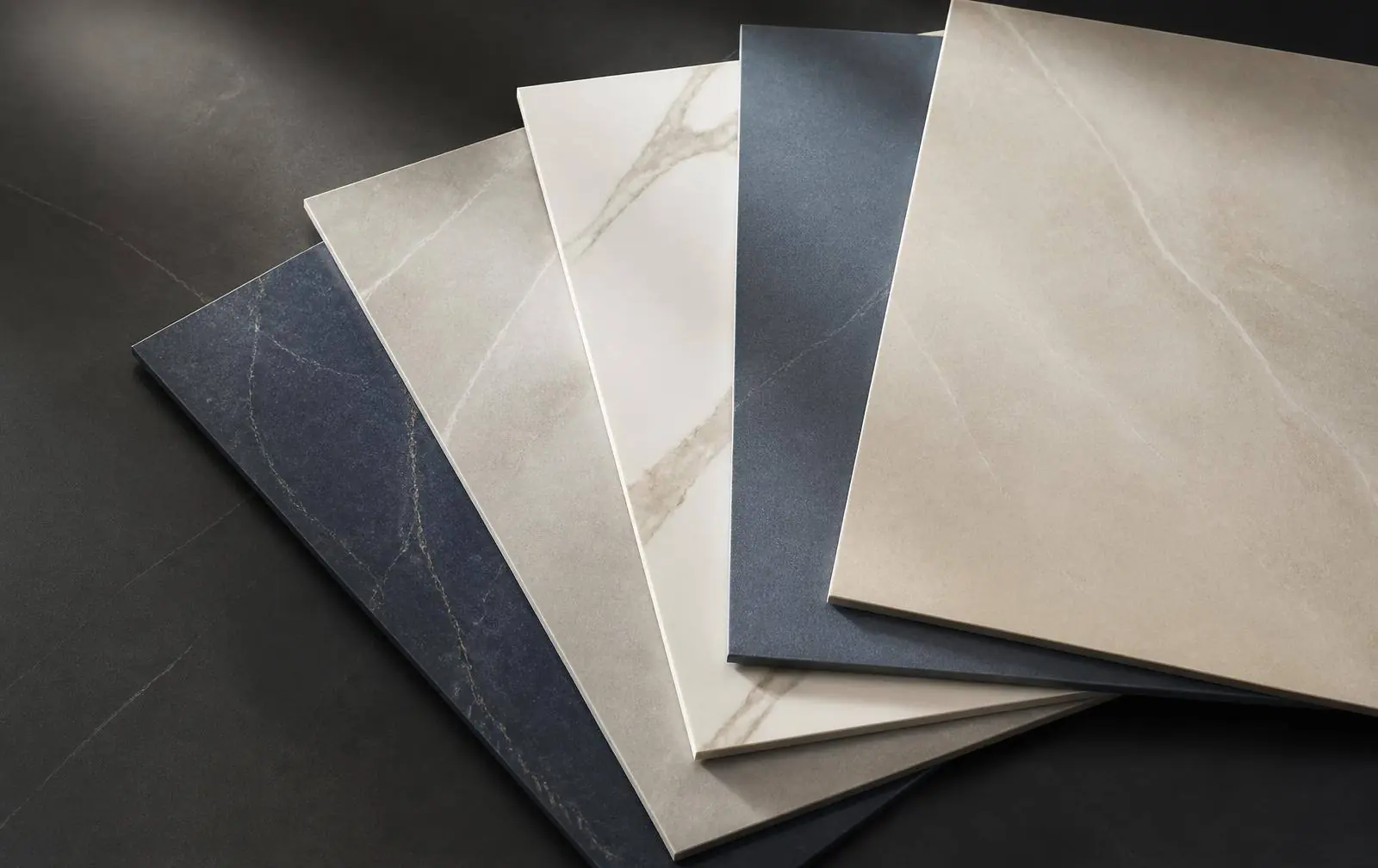 Porcelain and vitrified tile samples fanned out on a dark surface
